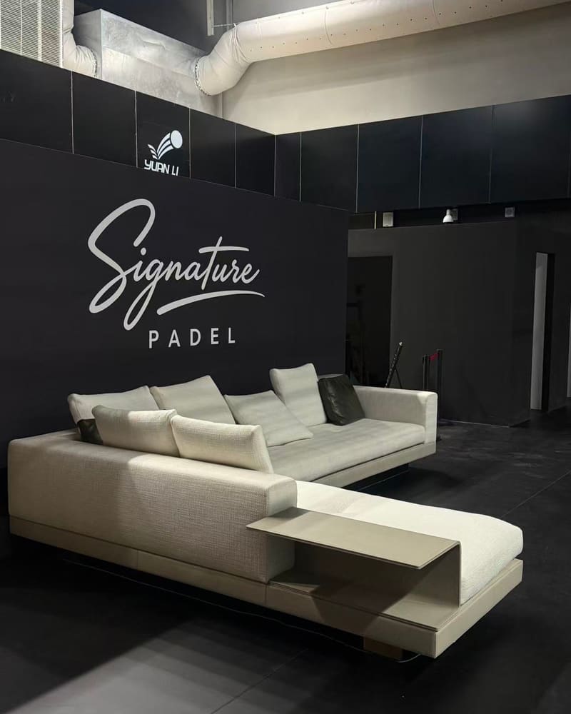 Signature Padel 标志墙前的休息区沙发